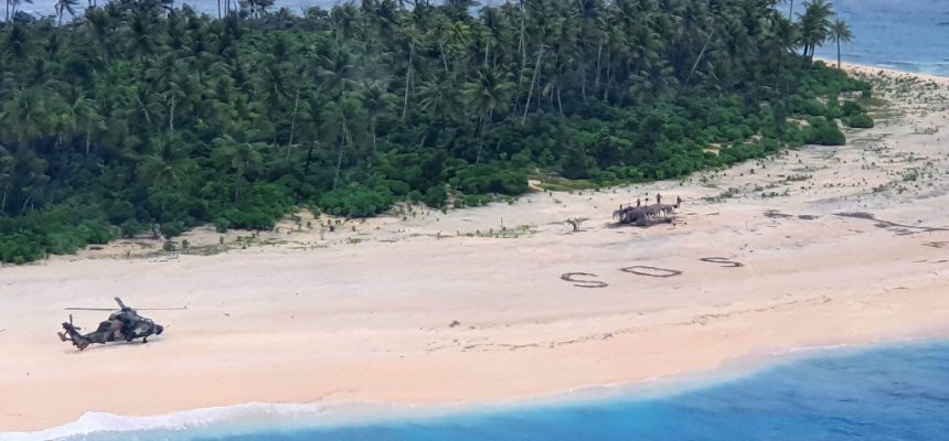 This handout photo taken on August 2, 2020 and received on August 4 from the Australian Defence Force shows an Australian Army ARH Tiger helicopter landing near the letters "SOS" (C) on a beach on Pikelot Island where three men were found in good condition after being missing for three days. - Three Micronesian sailors stranded on a tiny island in the remote Western Pacific were rescued after Australian and US warplanes spotted a giant "SOS" they had scrawled on the beach, officials said. (Photo by Handout / Australian Defence Force / AFP) / RESTRICTED TO EDITORIAL USE - MANDATORY CREDIT "AFP PHOTO / AUSTRALIAN DEFENCE FORCE" - NO MARKETING - NO ADVERTISING CAMPAIGNS - DISTRIBUTED AS A SERVICE TO CLIENTS